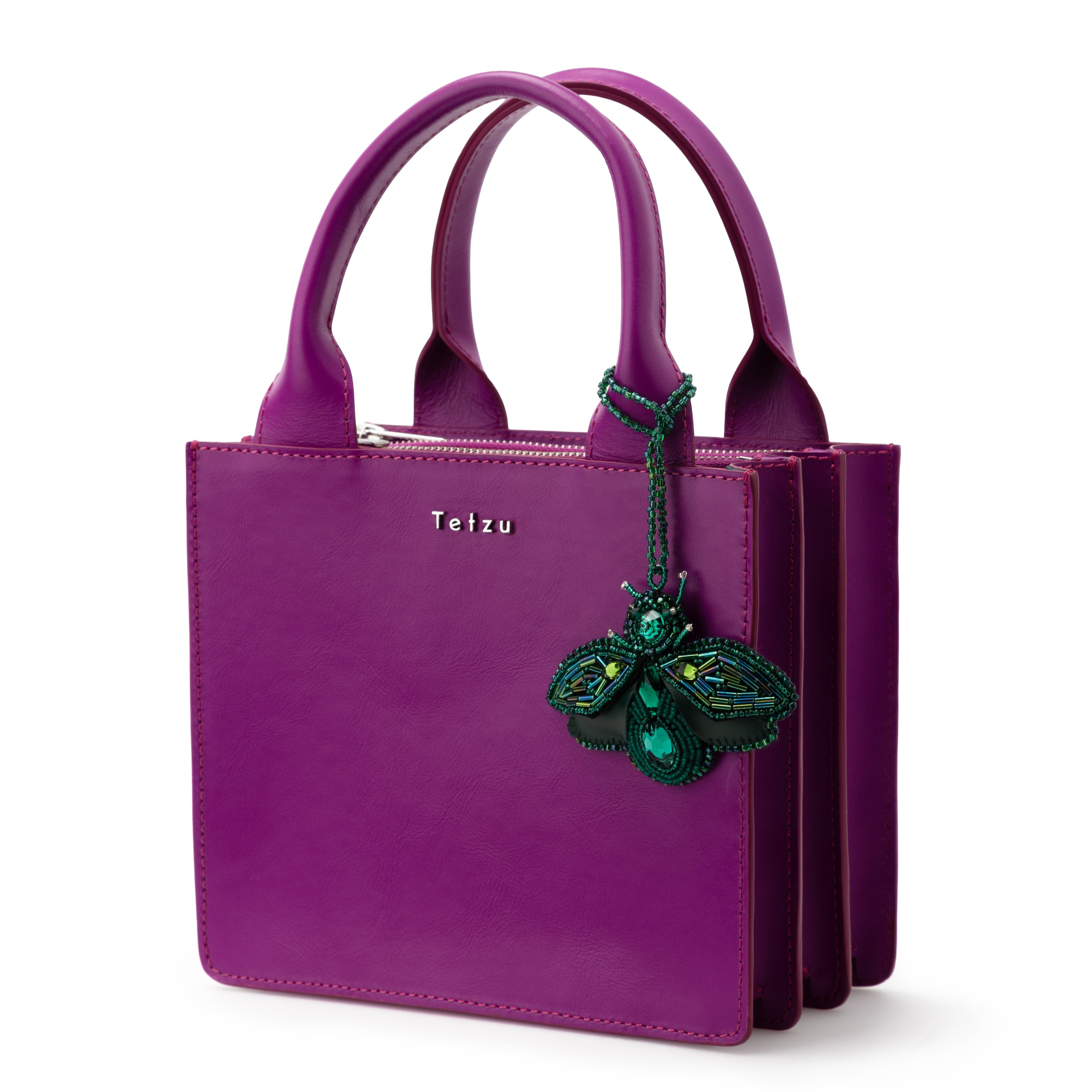 Green bag charm made from high-quality leather, featuring plastic bead embellishments and a signature logo on the back. Handcrafted in Portugal, this 6.5 cm x 9 cm keychain adds a sophisticated touch to any bag or keys.